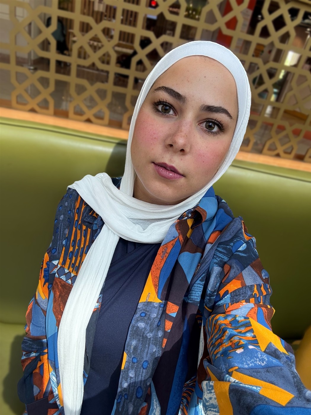 Portrait of Merit ElShenawy in a colorful patterned jacket